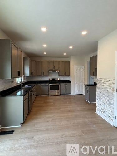 A spacious kitchen with wooden floors and modern appliances.