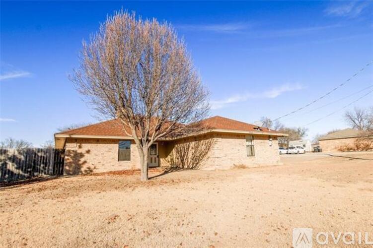 A house with a bare tree in front of it.