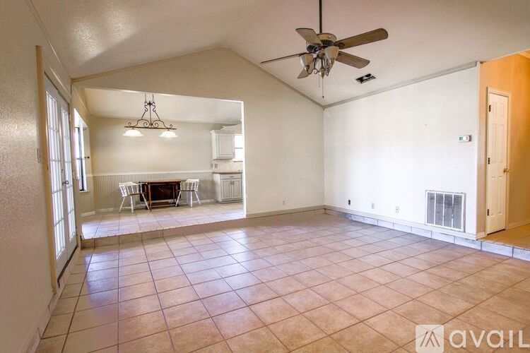 A spacious room with a ceiling fan and a dining table set up.