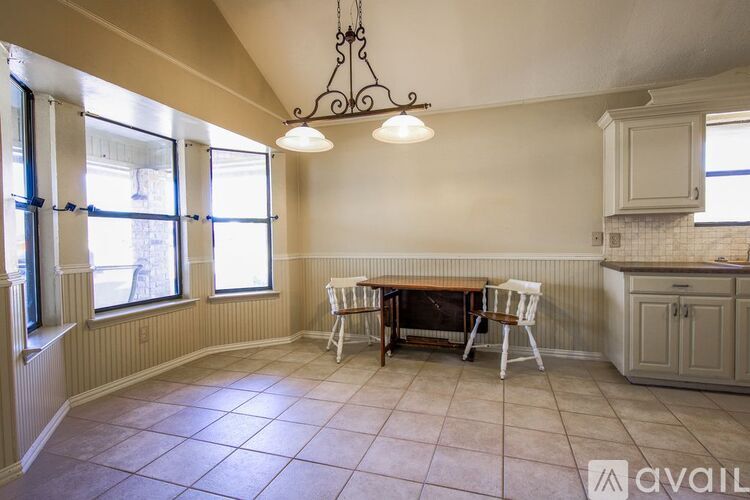 A dining room with a table and chairs.