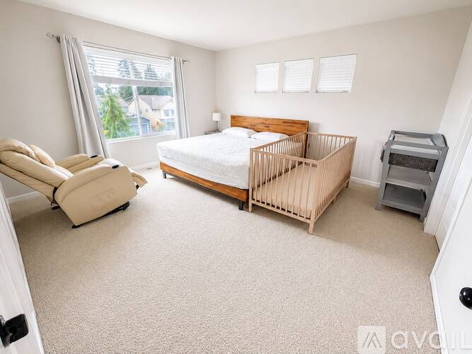A bedroom with a bed, chair, and printer.