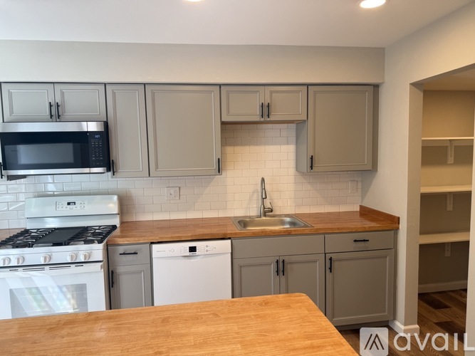 A kitchen with a stove, microwave, dishwasher, and sink.