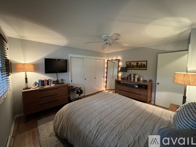 A bedroom with a large bed and a ceiling fan.