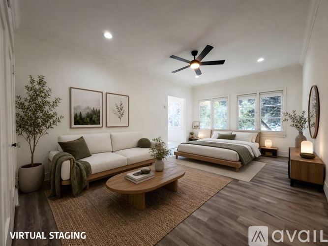 A well-lit, modern bedroom with a bed, couch, and a ceiling fan.