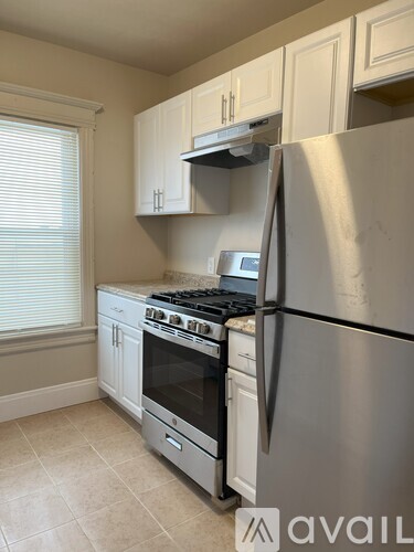 A kitchen with a stainless steel refrigerator, oven, and cabinets.