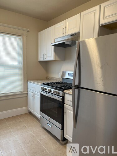 A kitchen with a stainless steel refrigerator, oven, and cabinets.