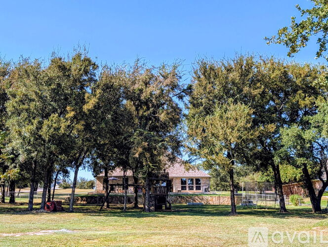 A house is surrounded by trees in a sunny day.