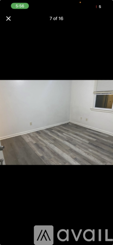 A room with wooden flooring and white walls.