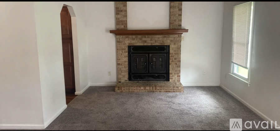 A living room with a fireplace and a window.