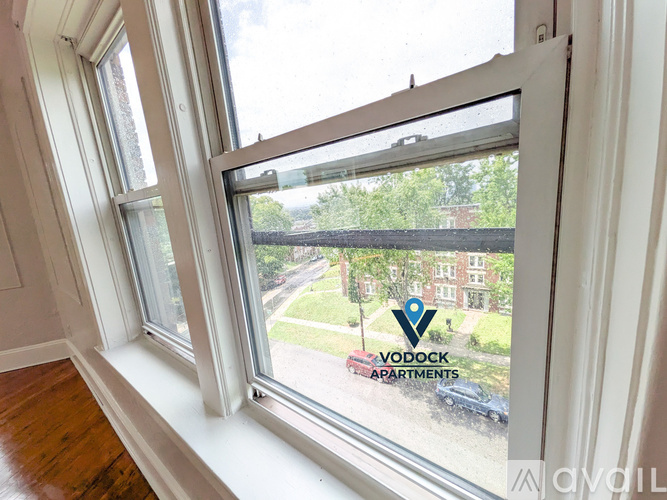 A window with a view of a street and buildings outside.
