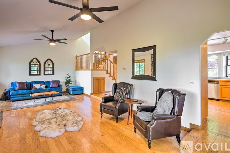 A living room with a blue sofa and a brown leather chair.