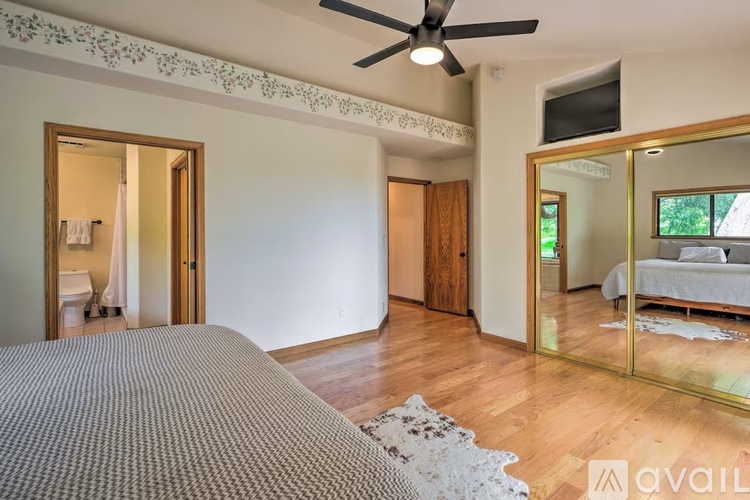 A bedroom with a large bed and a ceiling fan.