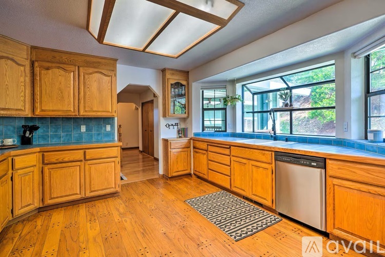 A kitchen with wooden cabinets and a blue backsplash.
