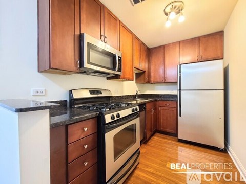 A kitchen with brown cabinets and a white refrigerator.