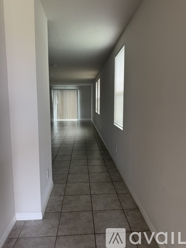 A long hallway with tiled floors and white walls.