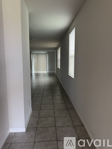 A long hallway with tiled floors and white walls.