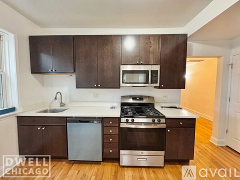 A kitchen with dark wood cabinets and stainless steel appliances.