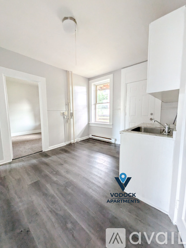 A spacious apartment kitchen with a sink and a window.