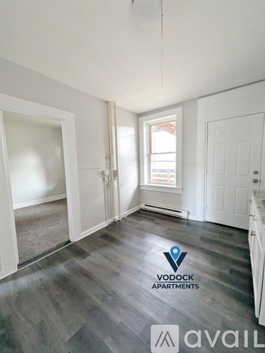 A room with a Vodock Apartments logo on the floor.