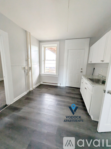A room with a Vodock Apartments logo on the floor.