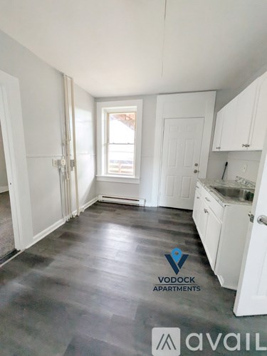 A room with a Vodock Apartments logo on the floor.