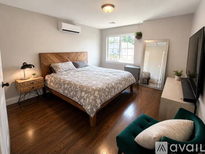 A bedroom with a large bed and a green armchair.