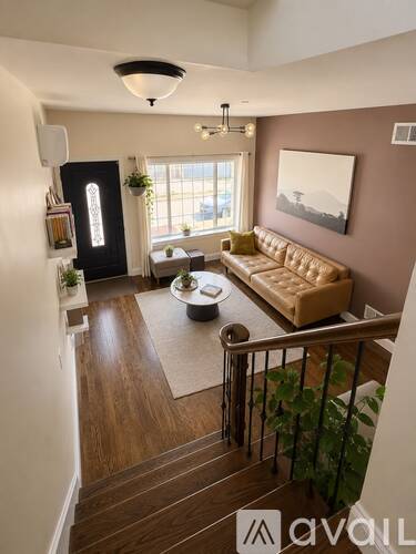 A living room with a couch, coffee table, and a painting on the wall.