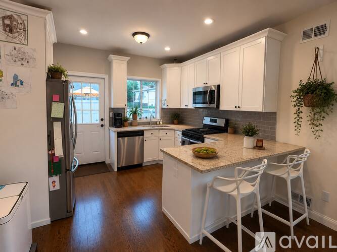 A kitchen with white cabinets and a granite countertop.