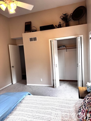 A bedroom with a bed and a mirror on the wall.