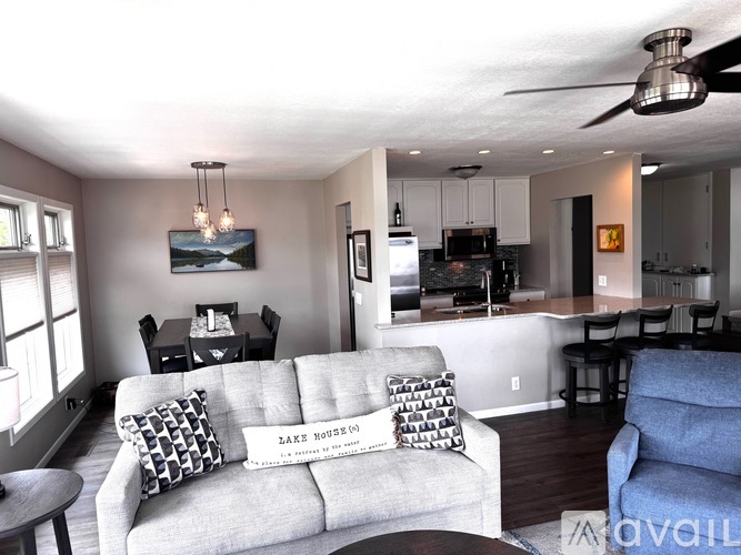 A living room with a grey couch and a ceiling fan.