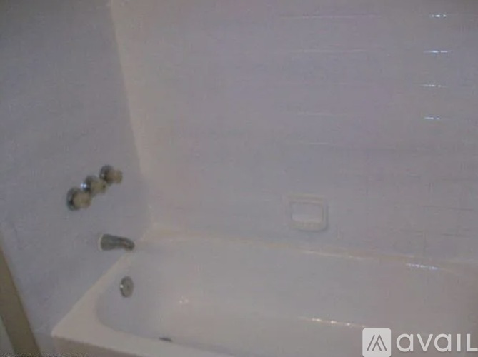 A white bathtub with a silver faucet and a silver drain.