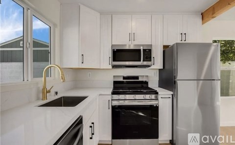 A kitchen with white cabinets and appliances.