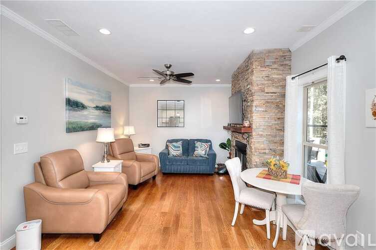 A living room with a white ceiling fan and a painting of a river on the wall.