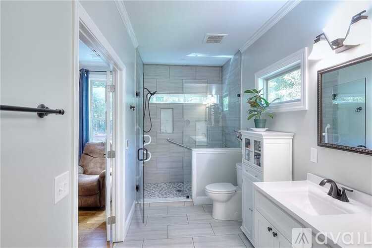 A bathroom with a toilet, sink, and shower.