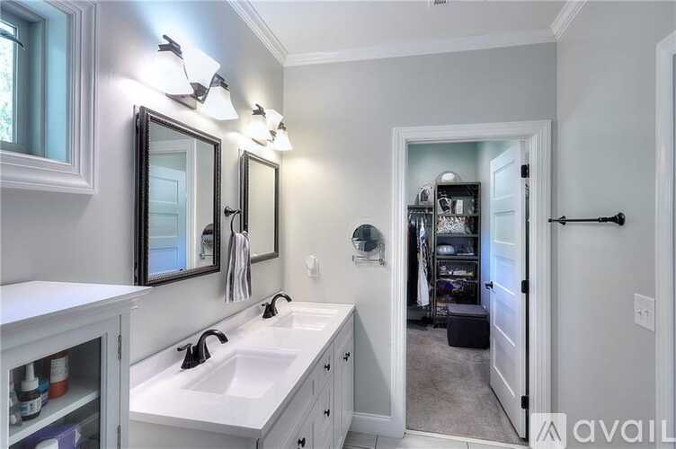 A bathroom with a white sink and a mirror above it.