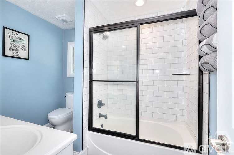 A white toilet sits next to a blue wall in a bathroom.