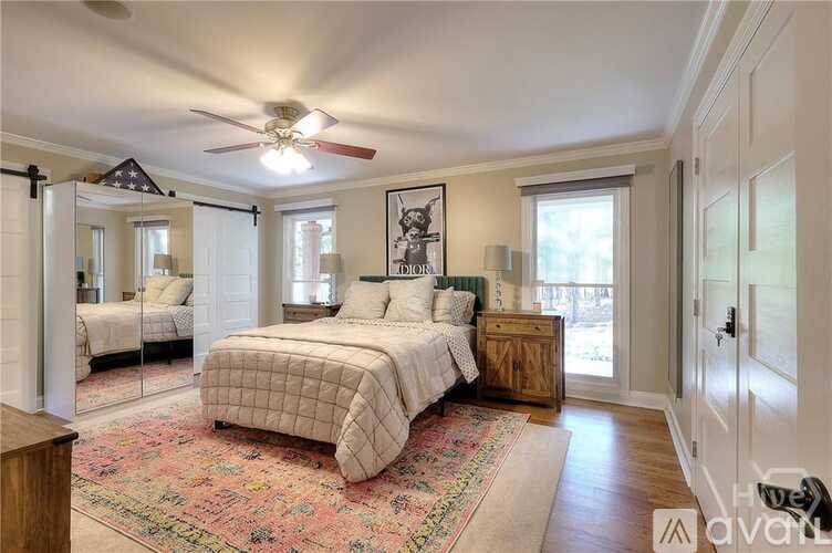 A bedroom with a large bed and a ceiling fan.
