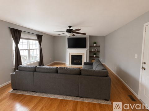 A living room with a grey couch and a fireplace.