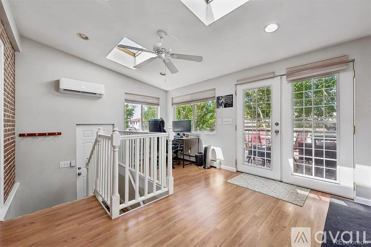 A spacious room with a skylight and a balcony with a railing.