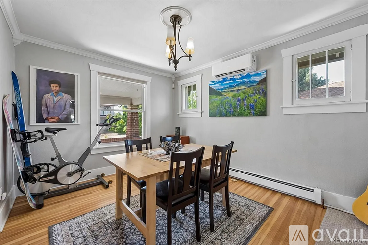 A dining room with a table and chairs and a bicycle in the corner.