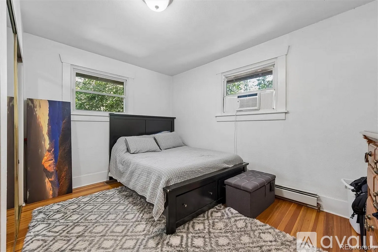A bedroom with a bed, nightstand, and window.