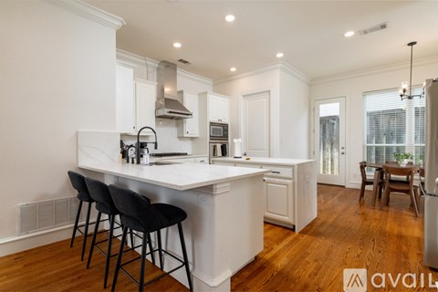 A kitchen with white cabinets and a wooden floor.