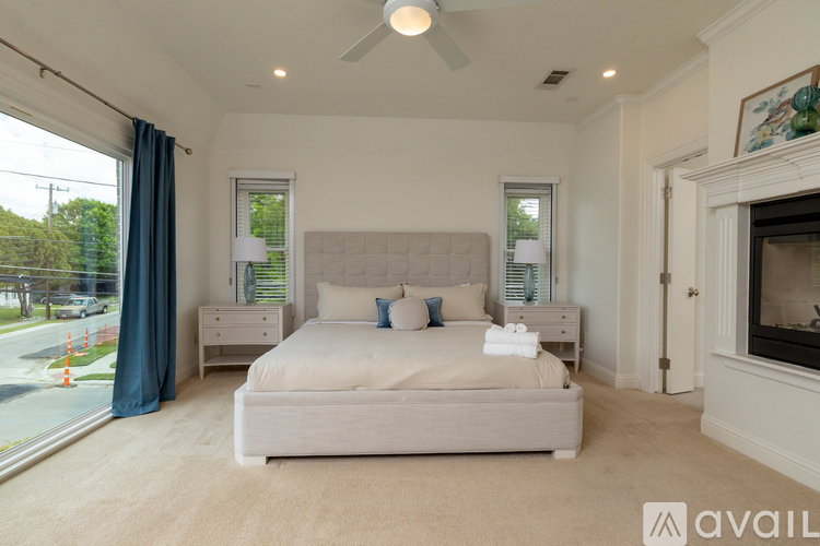 A bedroom with a large bed and a fireplace.