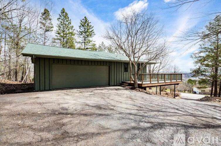 A green building with a porch and a covered garage door.