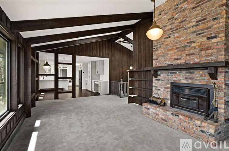 A large open space with a fireplace and wooden beams.