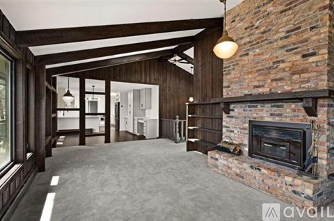 A large open space with a fireplace and wooden beams.