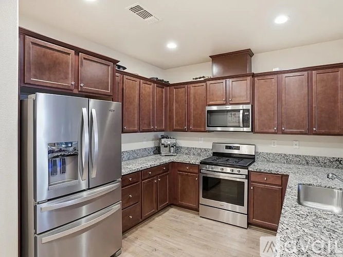 A kitchen with brown cabinets and stainless steel appliances.