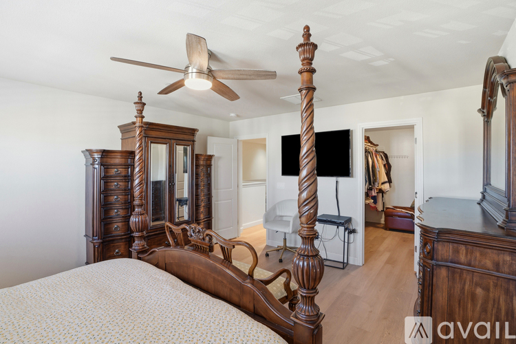 A bedroom with a large bed and a wooden dresser.