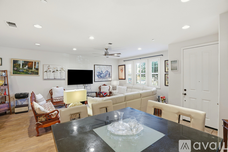 A living room with a glass table and a television.