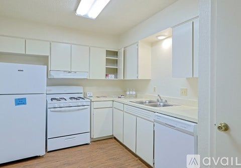 A kitchen with white appliances and cabinets.
